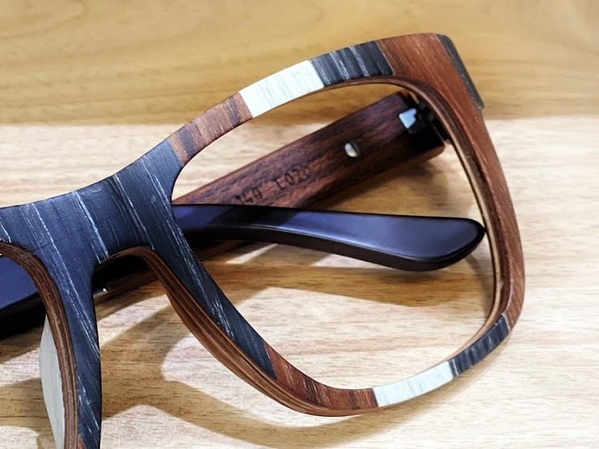 A wood laminate eyeglass frame on a counter at Urban Eyewear